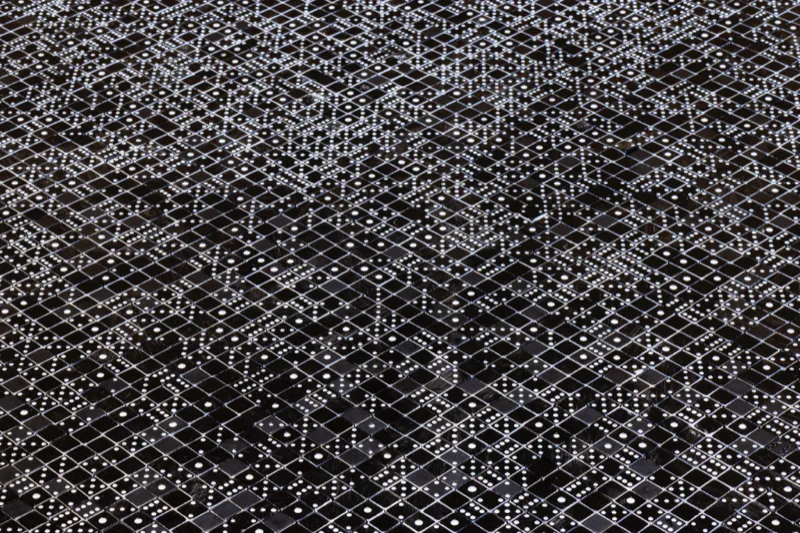 上面を黒く塗ったサイコロを敷き並べた作品